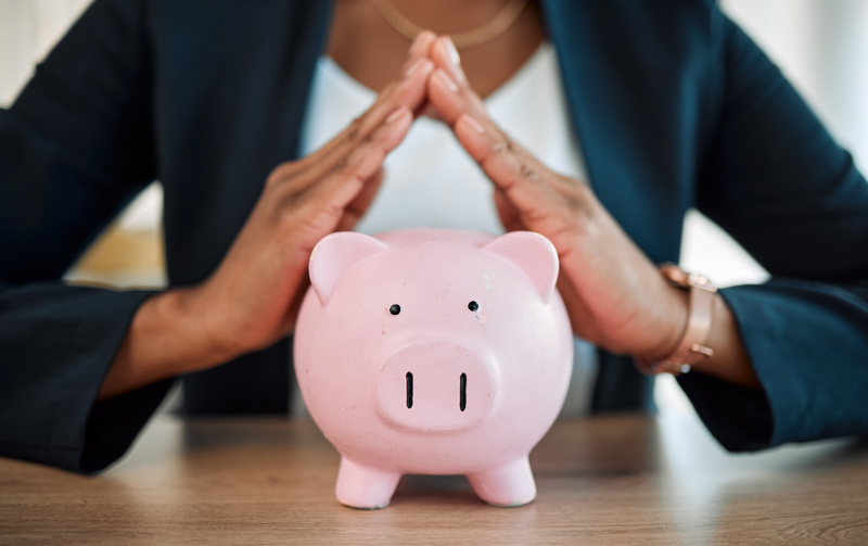 Piggy Bank with a person holding their hands over it with protection